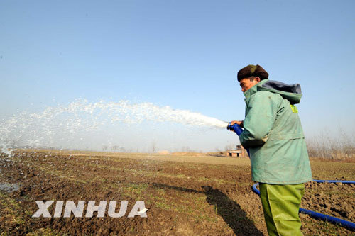 Photo taken on January 22, 2009 shows a villager was irrigating his wheat cropland threatened by the drought in Shuanglong Village, Yongxing Township, Lixin County, Anhui Province. 