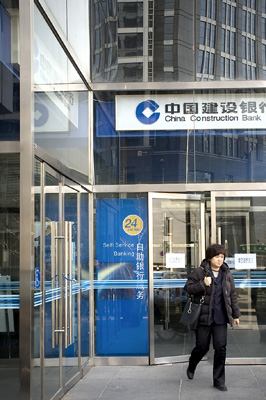 A woman leaves a China Construction Bank Corp branch in Beijing. The lender yesterday said it received regulatory approval to raise as much as 40 billion yuan (US$5.8 billion) selling subordinated bonds to boost capital.