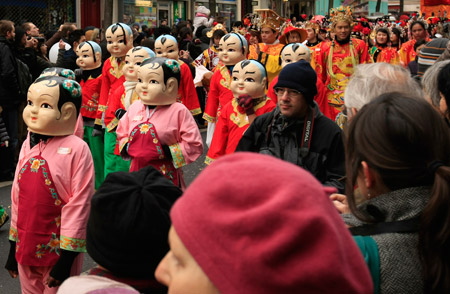 A group of traditional Chinese "big-head children" parade during a Chinese Lunar New Year celebration at a China Town in Paris, capital of France, on Feb. 1, 2009. (Xinhua/Zhang Yuwei)