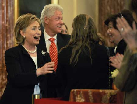 U.S. Secretary of State Hillary Clinton (L) and her husband, former U.S. President Bill Clinton, greet people as they arrive for her ceremonial swearing-in at the State Department in Washington, Feb. 2, 2009.