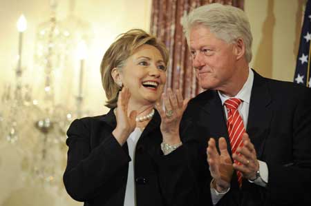 U.S. Secretary of State Hillary Clinton (L) takes the stage, beside her husband former U.S. President Bill Clinton, before being ceremonially sworn in at the State Department in Washington, Feb. 2, 2009.