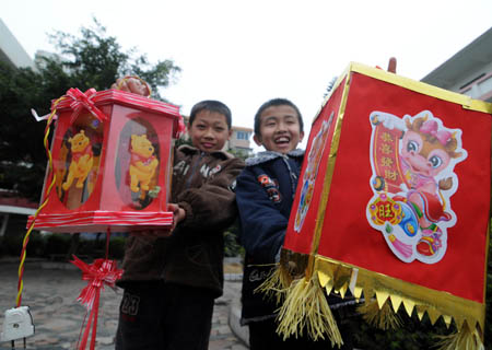  Two pupils at Hexi primary school show their made lanterns in Liuzhou, southwest China's Guangxi Zhuang Autonomous Region, Feb. 3, 2009. Pupils in Liuzhou made lanterns for the lantern show during the Chinese Lantern Festival, which falls on Feb. 9 this year. (Xinhua/Huang Xiaobang)