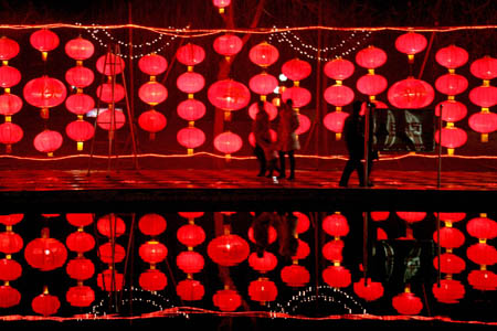 People enjoy the red lantern wall in Yongji city, north China's Shanxi Province, Feb. 2, 2009. Various lanterns are geared up for the impending Chinese Lantern Festival, which falls on Feb. 9 this year. 