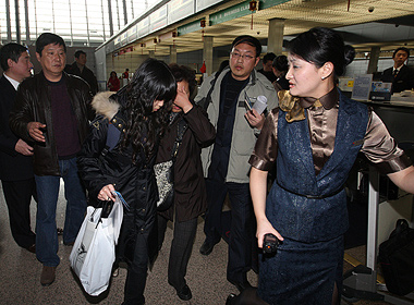 A China Eastern Airline official leads relatives of the Chinese victims of the Arizona bus crash to their flight this afternoon. Thirteen relatives caught Flight MU1183 to Los Angeles. A second group of relatives will depart tomorrow.