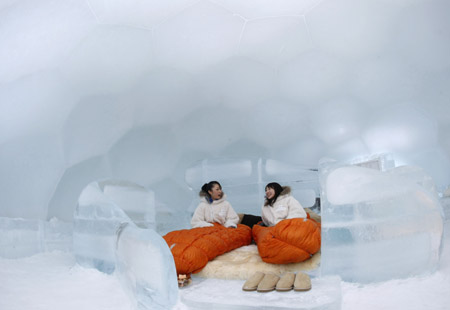 Women sit on the bed of an ice hotel during a photo opportunity in the Alpha Resort-Tomamu's ice village in Shimukappu town, Japan's northern island of Hokkaido Feb. 3, 2009. (Xinhua/Reuters Photo)