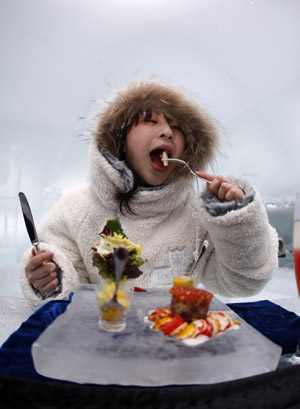 A woman eats dinner, served on an ice plate at the ice hotel during a photo opportunity in the Alpha Resort-Tomamu's ice village in Shimukappu town, Japan's northern island of Hokkaido, Feb. 3, 2009.(Xinhua/Reuters Photo)