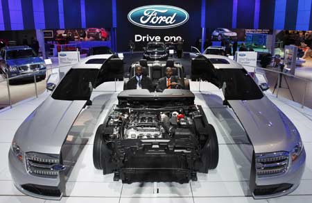 The 2010 Ford Taurus exterior designer Earl Lucas (L) and product specialist Clinton Vicks are seen in Taurus display that splits the body to showcase the inside of the car during the North American International Auto Show in Detroit, Michigan Jan. 13, 2009.