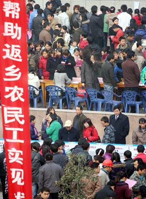  People search for job information at the job fair for migrant workers held in Jingmen City, central China's Hubei Province, on Feb. 4, 2009. Some 7,000 job vacancies of 130 enterprises were provided to migrant workers at the job fair. [Xinhua]