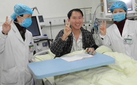 The bird flu patient surnamed Zhou poses for photograph with hospital staff before leaving the isolation ward at Guizhou Provincial People's Hospital in Guiyang, the provincial capital of southwest China's Guizhou, on Tuesday, Feb. 3, 2009. The 29-year-old man was hospitalized for fever on January 15 and was confirmed to be infected with bird flu on January 24. Doctors said on Feb. 2 that he was in stable condition. [Photo: Xinhua/Yang Ying]