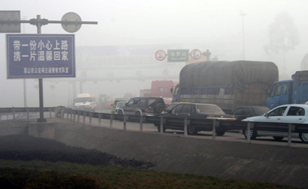 Vehicles wait for the operation of the Meishan Toll Gate on the Chengle Freeway in Meishan City, southwest China's Sichuan Province, Feb. 4, 2009. A heavy fog hit Meishan on Wednesday, causing the closure of the Chengle Freeway connecting Chengdu, capital of Sichuan, and Leshan City, also in the province. [Yao Yongliang/Xinhua]