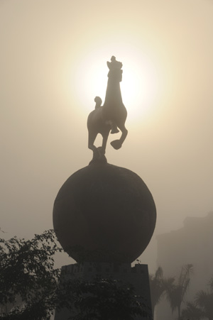 A sculpture is wrapped in fog along the street of Qionghai City, south China's Hainan Province, Feb. 4, 2009. [Meng Zhongde/Xinhua]