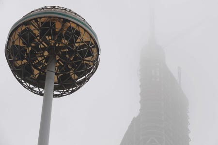  The 400-meter-tall Zifeng Mansion under construction is shrouded by fog in Nanjing, capital of east China's Jiangsu Province, Feb. 4, 2009. [Sun Can/Xinhua]