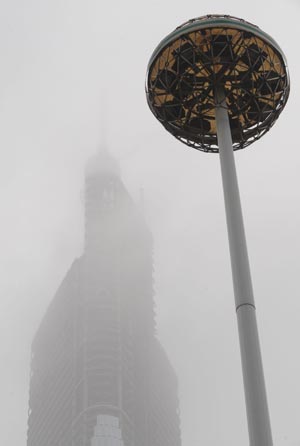 The 400-meter-tall Zifeng Mansion under construction is shrouded by fog in Nanjing, capital of east China's Jiangsu Province, Feb. 4, 2009. [Sun Can/Xinhua] 