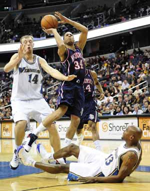 New Jersey Nets' Devin Harris (C) shoots past Washington Wizards' Mike James (R) and Oleksiy Pecherov during their NBA game held in Washington, the United States, February 4, 2009. New Jersey Nets won 115-88.