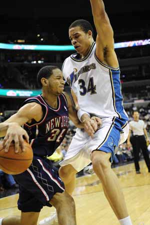 New Jersey Nets' Devin Harris (L) breaks through past JaVale McGee of Washington Wizards during their NBA game held in Washington, the United States, February 4, 2009. New Jersey Nets won 115-88. 