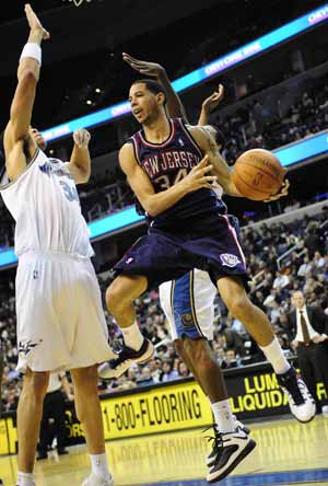 New Jersey Nets' Devin Harris (R) shoot past JaVale McGee of Washington Wizards during their NBA game held in Washington, the United States, February 4, 2009. New Jersey Nets won 115-88. 