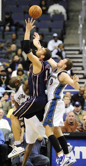 New Jersey Nets' Brook Lopez (C) shoots past Washington Wizards' Antawn Jaminson (1st, L) and Darius Songaila during their NBA game held in Washington, the United States, February 4, 2009. New Jersey Nets won 115-88. 
