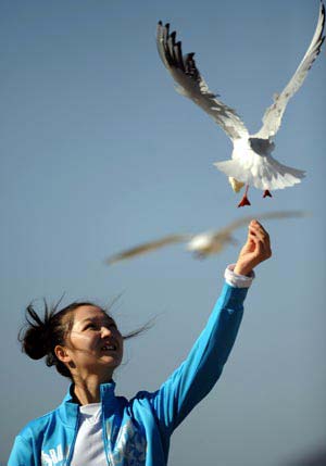 A girl feeds a red-beaked gull as she enjoys the spring sunshine in Kunming, capital of southwest China's Yunnan Province, Feb. 4, 2009. (Xinhua/Qin Qing) 