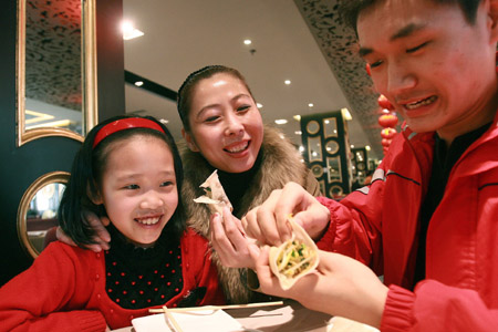 A family eat spring pancakes at a restaurant in Beijing, capital of China, on Feb. 4, 2009, the Spring Begins, first of the 24 solar terms in China's lunar calendar. People in north China have the tradition to eat spring pancakes on the day. (Xinhua/Chen Xiaogen)