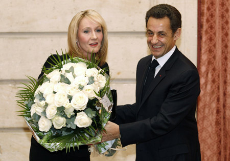 British author J.K. Rowling (L) accepts a bouquet from France's President Nicolas Sarkozy during an awards ceremony where she was named Chevalier de la Legion d'Honneur at the Elysee Palace Feb. 3, 2009.