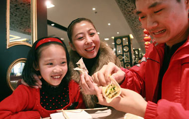 A family eat spring pancakes at a restaurant in Beijing, capital of China, on Feb. 4, 2009, the Spring Begins, first of the 24 solar terms in China's lunar calendar. People in north China have the tradition to eat spring pancakes on the day.