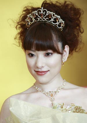 A model displays gold thread made wedding dresses and tiaras designed by Japanese designer Yumi Katsura, and priced 70 million Japanese Yen in Tokyo Feb. 4, 2009.(Xinhua/Ren Zhenglai) 