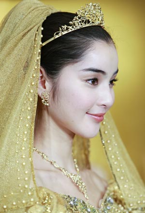 A model displays gold thread made wedding dresses, and tiaras designed by Japanese designer Yumi Katsura, priced 30 million Japanese Yen in Tokyo Feb. 4, 2009.(Xinhua/Ren Zhenglai) 