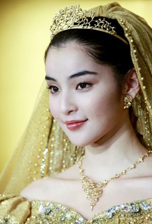 A model displays gold thread made wedding dresses, and tiaras, designed by Japanese designer Yumi Katsura and priced 30 million Japanese Yen in Tokyo Feb. 4, 2009. (Xinhua/Ren Zhenglai)