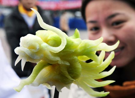 A visitor looks at a sculpture made of radish in the shape of dragon's head during a food carving competition in Qingdao, east China's Shandong Province, Feb. 4, 2009.