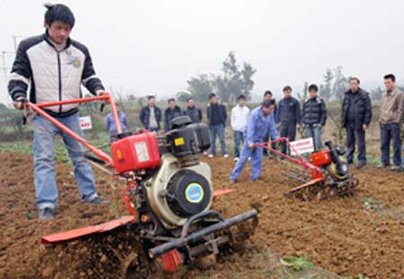 Farmers learn to operate a ploughing machine under the instruction of technicians at Renhe Village of Baixi Township in Yibin County, southwest China's Sichuan Province, Feb. 2, 2009. As the spring ploughing starts in south China, technical trains are given to the farmers there to help them raise efficiency.