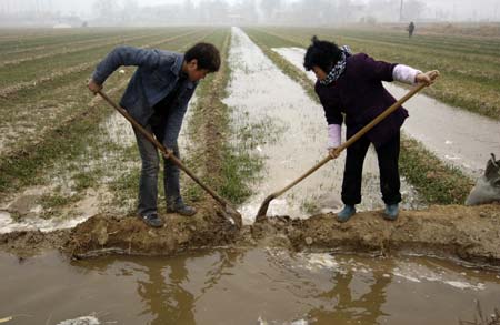 Farmers irrigate a cornfield in Sanyuan County, northwest China's Shaanxi Province, Feb. 3, 2009. Shaanxi Province is an important production area of grain crops of China in summers, but nine cities of the province encountered drought as there was no rainfall since mid-November. So far, 1.17 million people each day are engaged in field irrigation, with more than 60,000 irrigation facilities operated. (Xinhua/Chen Gang)