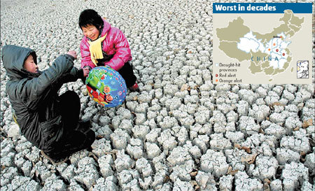 Children play on a dried up pond in Tangyin county, Henan province, on Tuesday. The province has been hit by its most severe drought since 1951, with no rain for more than 100 days. [Chang Zhongzheng/China Daily] 