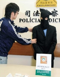 Police detains a Hong Kong man suspected of deliberately spending counterfeit RMB banknotes in Macau February 5, 2009. [Photo: Macao Daily] 