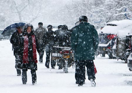 Residents walk in snow in Altay area in northwest China's Xinjiang Uygur Autonomous Region Feb. 5, 2009. A heavy snowfall hit Altay on Thursday. Local government has sent over 100 workers to the pasturing area to help herdsmen fight against chilliness. [Liu Xinhai/Xinhua] 