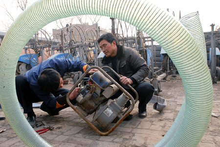 Members of a drought relief working team overhaul a water pump in Linfen, north China's Shanxi Province, Feb. 5, 2009. China raised the drought emergency class Thursday from level two to level one, the highest alert, in response to the worst drought to hit northern China in half a century, according to a State Council meeting. [Yan Ruipeng/Xinhua] 