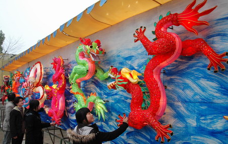 People watch a paper-made Nine Dragon Wall that will be displayed at a park in Suzhou, Jiangsu Province, February 4, 2009. The Lantern Festival is the last day of the Chinese New Year and falls on February 9 this year. [Xinhua] 