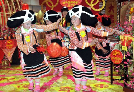 Girls of an old branch of the Miao ethnic group, dressed in traditional costumes with unique hair style like ox's horn, from southwest China's Guizhou Province dance in south China's Hong Kong, Feb. 5, 2009.(Xinhua/Wong Pun Keung)