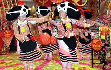 Girls of an old branch of the Miao ethnic group, dressed in traditional costumes with unique hair style like ox's horn, from southwest China's Guizhou Province dance in south China's Hong Kong, Feb. 5, 2009.