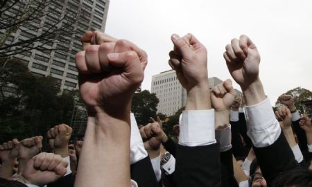 Japanese college students raise their fists at a job-hunting rally in Tokyo February 5, 2009. Some 3,000 students from business schools kicked off their efforts to job-hunt and held a morale-boosting rally.