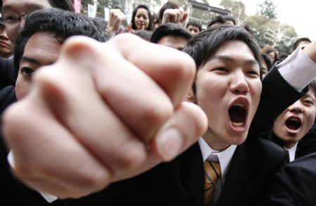 Japanese college students raise their fists at a job-hunting rally in Tokyo February 5, 2009. Some 3,000 students from business schools kicked off their efforts to job-hunt and held a morale-boosting rally. 