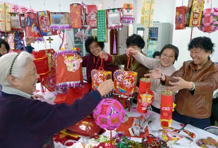 Residents make lanterns with waste packaging during a contest to mark the impending Chinese Lantern Festival, which falls on Feb. 9 this year, at Min'an Community of Dongcheng District in Beijing, capital of China, Feb. 5, 2009. (Xinhua/Jiang Jun)