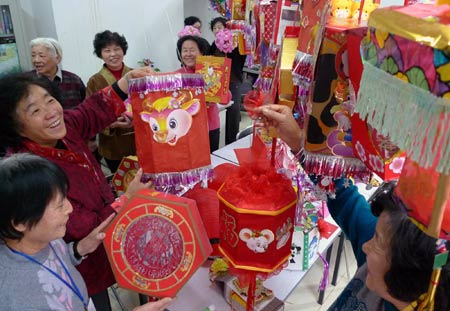 Residents make lanterns with waste packaging during a contest to mark the impending Chinese Lantern Festival, which falls on Feb. 9 this year, at Min'an Community of Dongcheng District in Beijing, capital of China, Feb. 5, 2009.(Xinhua/Jiang Jun)