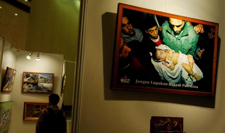  A visitor looks at pictures of Palestinian children during a charity event aimed to help Palestinian children and women, in Jakarta, capital of Indonesia, Feb. 5, 2009. The money donated in the event will be used to buy medicine and medical equipments for the Palestinians. [Yue Yuewei/Xinhua]