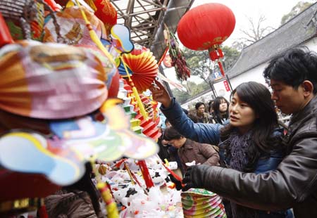 People buy colorful lanterns at a market in Shanghai, east China, Feb. 6, 2009. Colorful lanterns are popular decorations during the Chinese traditional Lantern Festival, which falls on the 15th day of the first month on the Chinese lunar calendar, or Feb. 9 this year.[Xinhua]