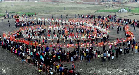  Farmers perform Banqiao dragon lantern dance at Zhangjiadun Village of Leping City, east China's Jiangxi Province, Feb. 6, 2009. The Banqiao dragon lantern, with a length of 400 meters, has a history of hundreds of years at the village. The villagers performed Banqiao dragon lantern dance on Friday to pray for harvest and peace, ahead of the Chinese traditional Lantern Festival, which falls on the 15th day of the first month on the Chinese lunar calendar, or Feb. 9 this year. [Xinhua]