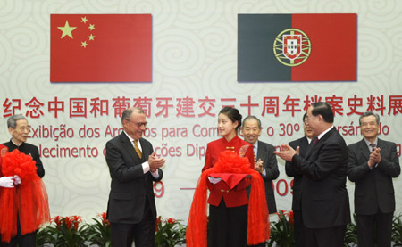 Chinese Assistant Foreign Minister Wu Hongbo (R, Front) and Portuguese ambassador to China Rui Quartin Santos (L, Front) cut ribbon during the opening ceremony of exhibition of archives recording the establishment of diplomatic relations between China and Portugal for 30 years in Beijing, China, on Feb. 6, 2009.[Xing Guangli/Xinhua]