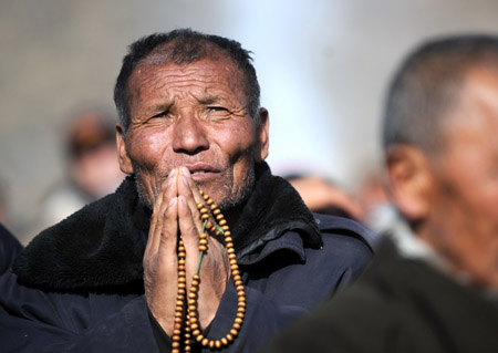 A Tibetan man prays during the Buddha Unveiling Festival in Labrang Lamasery in Xiahe County, Gannan Tibetan Autonomous Prefecture, northwest China's Gansu Province, Feb. 7, 2009. The annual festival falls on the 13th day of the first month on the Chinese Lunar Calendar, with a key activity of unveiling a Buddha portrait in the sun. (Xinhua/Nie Jianjiang)