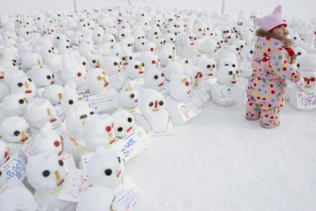 A little girl plays among snowmen made by children during the 60th Sapporo Snow Festival in Sapporo, Hokkaido prefecture, northern Japan, Feb. 7, 2009. About 300 snow and ice sculptures are on display during the festival held from Feb. 5 to 11 this year. As the largest winter tourism event of Japan, the Sapporo Snow Festival attracts an annual average of about two million visitors in the last 5 years. (Xinhua/Ren Zhenglai)