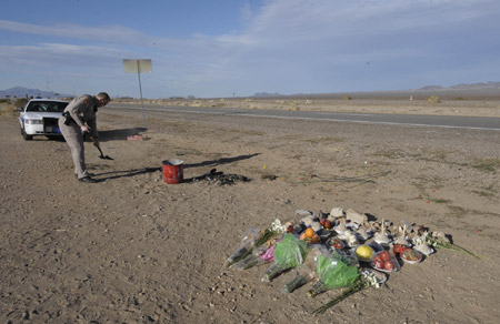 The offerings for the dead Chinese tourists in the traffic accident are placed at the accident site along the 93 highway in Arizona, the United States, Feb. 5, 2009. A bus carrying 15 Chinese tourists, a driver and a tour guide, crashed last Friday on the road. Six Chinese tourists and a local tour guide died. Nine Chinese tourists and the local driver were injured. 