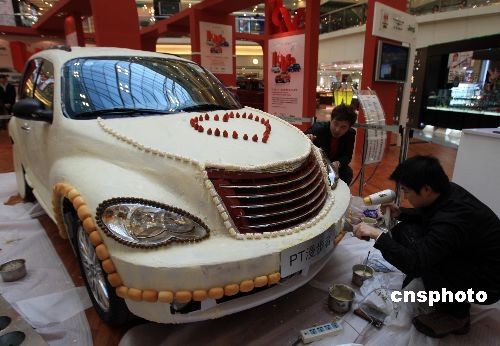 Two chocolate craftsmen in Shanghai are finishing their last touches in covering a car with over 200 kilograms of white chocolate, on Sunday, February 8, 2009. The choco-car is designed in celebration of the upcoming Saint Valentine's Day which falls on February 14 each year. [Photo: cnsphoto]